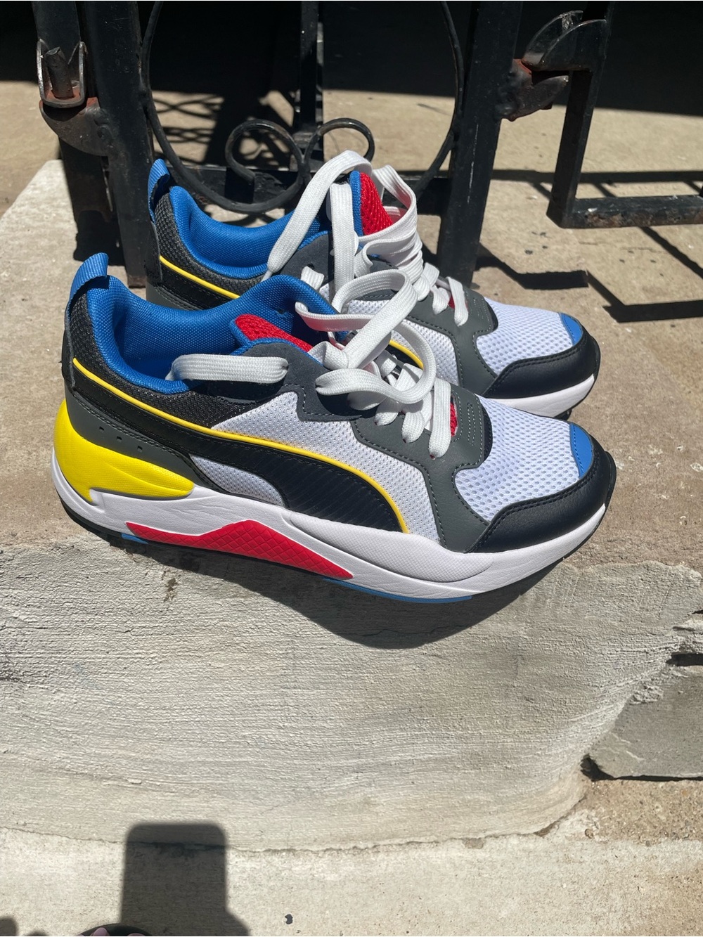 Puma Kids White Sneakers with Blue, Yellow, Red and Black Accents
